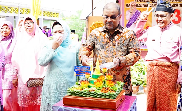 Bupati Karimun saat memotong tumpeng. (Foto Diskominfo Karimun)